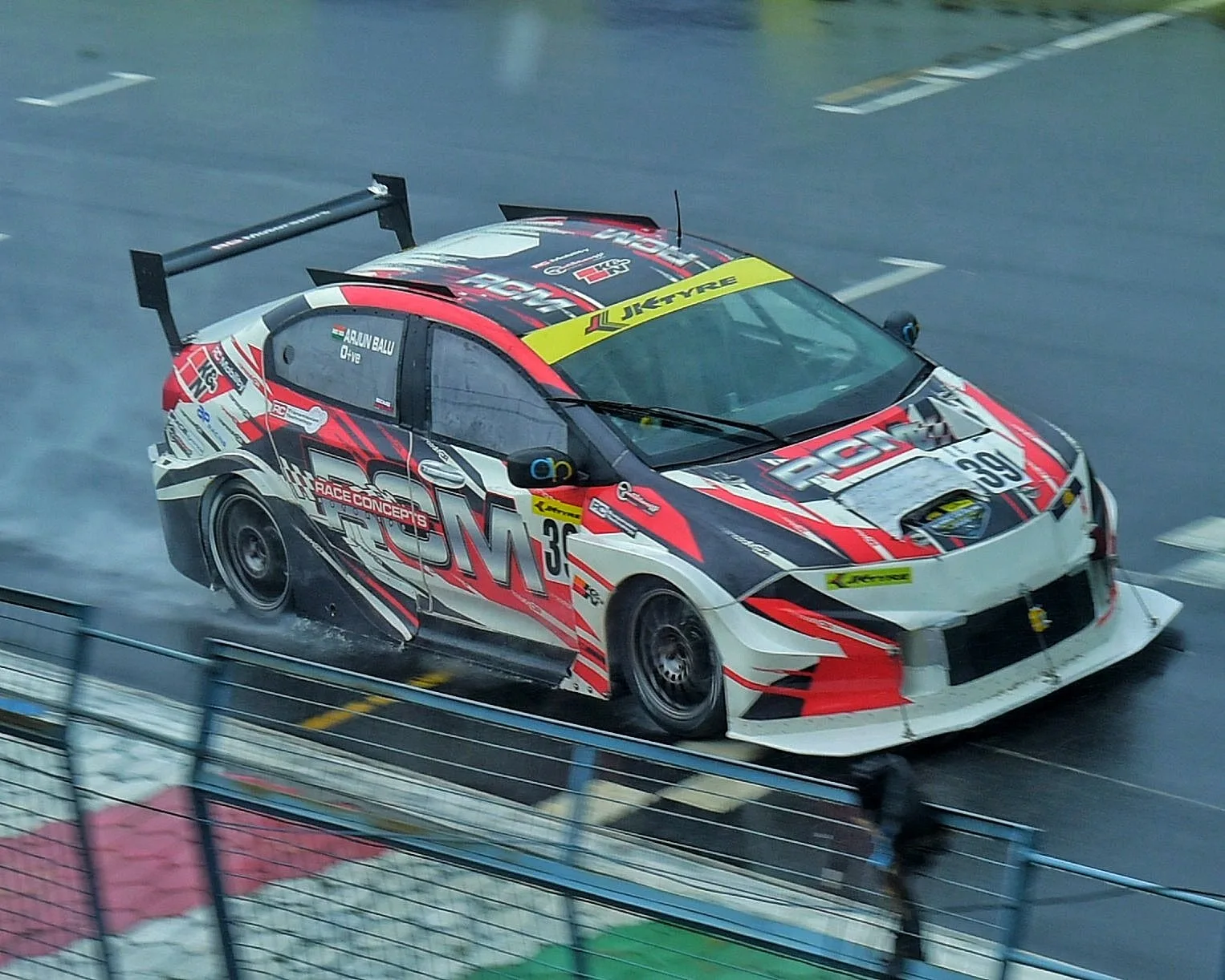 Saloon cars throwing up spray in the rain