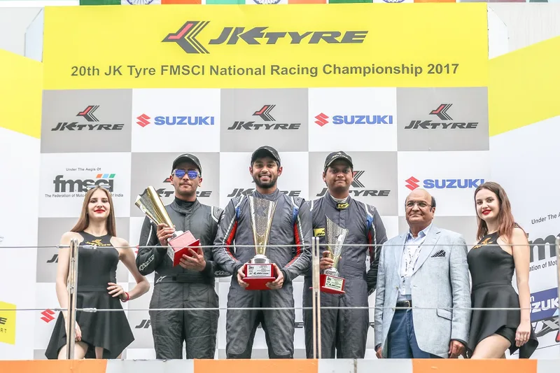 Champions hold their trophies on the podium of the 20th JK Tyre FMSCI National Racing Championship