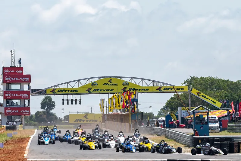 Formula cars pull away from the start beneath the gantry at Kari Motor Speedway, Coimbatore